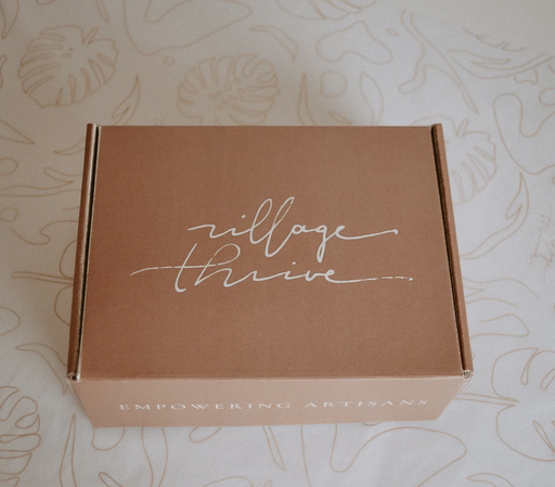 Village Thrive provides a unique and meaningful corporate gifting program, offering beautifully curated gift boxes that are sure to leave a lasting impression. Photo of terracotta box with village thrive logo